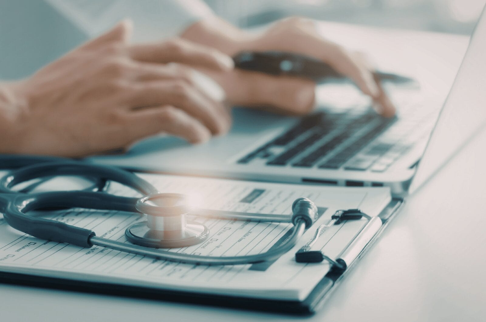hands with doctor's items and laptop